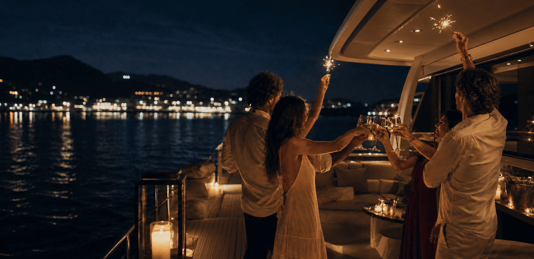 Friends raising glasses and sparklers against harbor lights